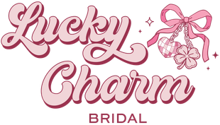 "Lucky Charm Bridal" logo with cursive text, pink bow, charms, and clover.