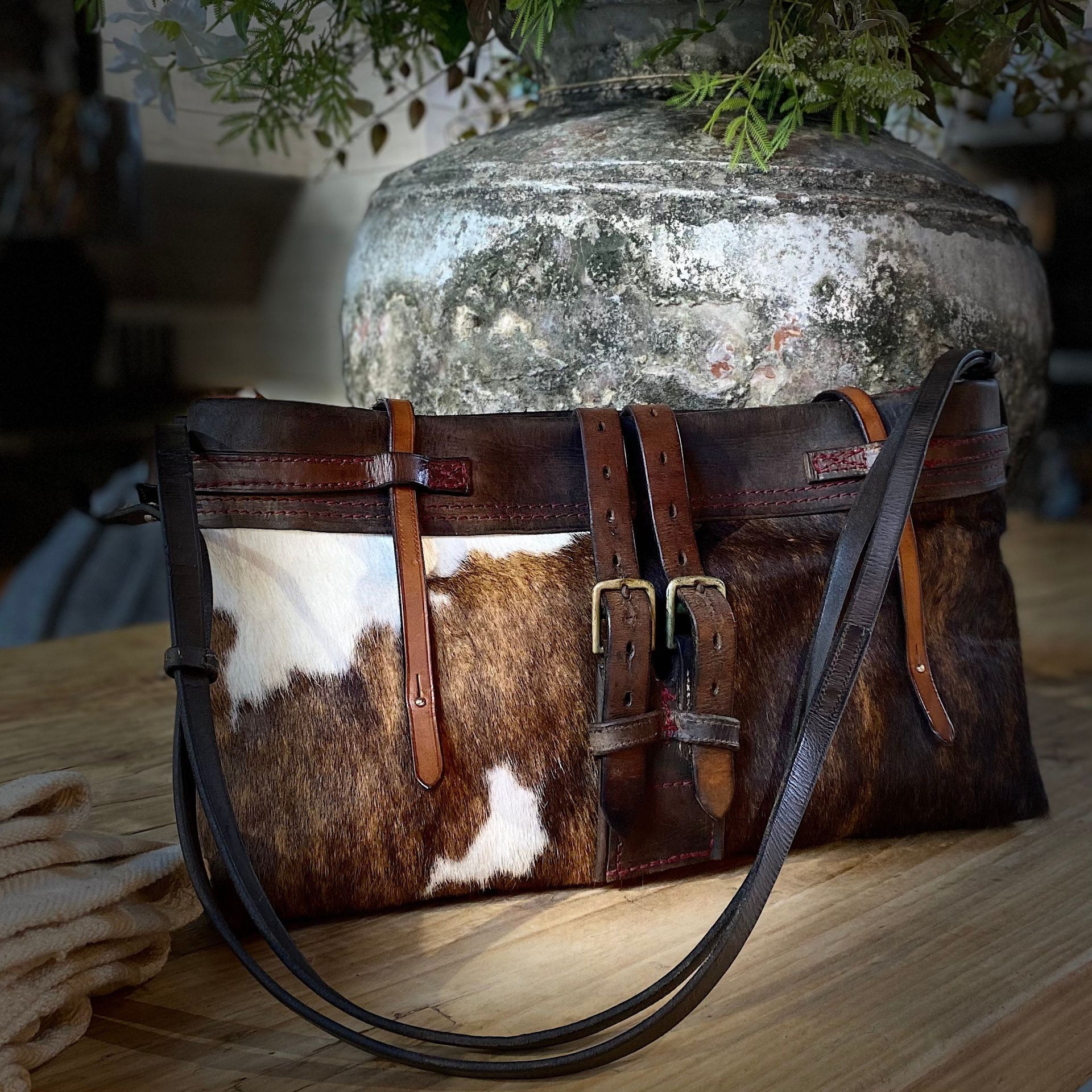 Cow hide cow skin shoulder to crossbody bag separate zipped red felt liner .