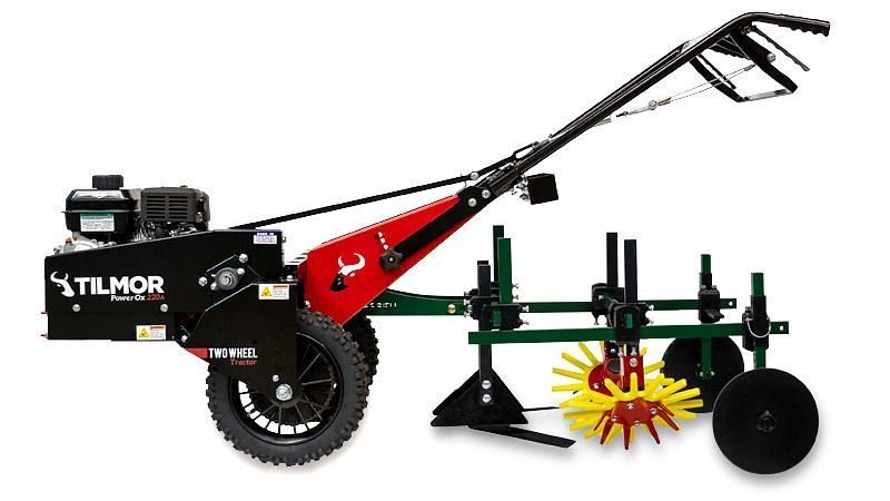 Tillmor walk-behind tractor with red frame, black wheels, and green tilling attachment on white background