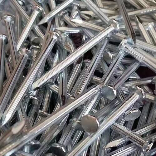 A pile of nails are sitting on top of each other on a table.