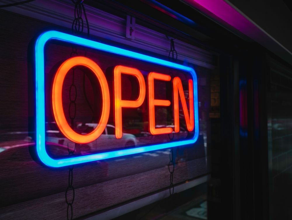 Neon sign, blue border, orange letters spelling 