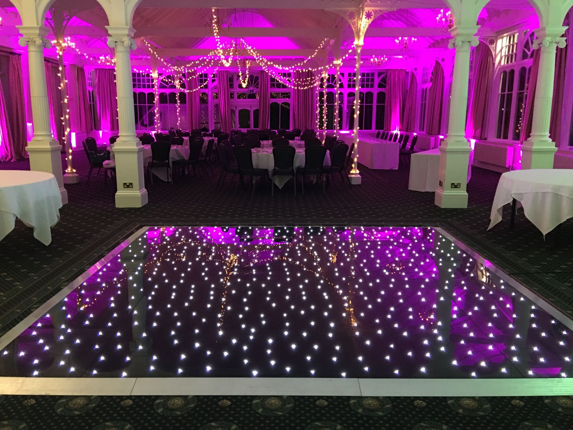 Large event space lit with warm white and pink lighting. Black base with sparkly white lights for this light up dance floor. Production services and equipment  hire for this event was supplied by Exclusive Entertainments Harrogate,Yorkshire
