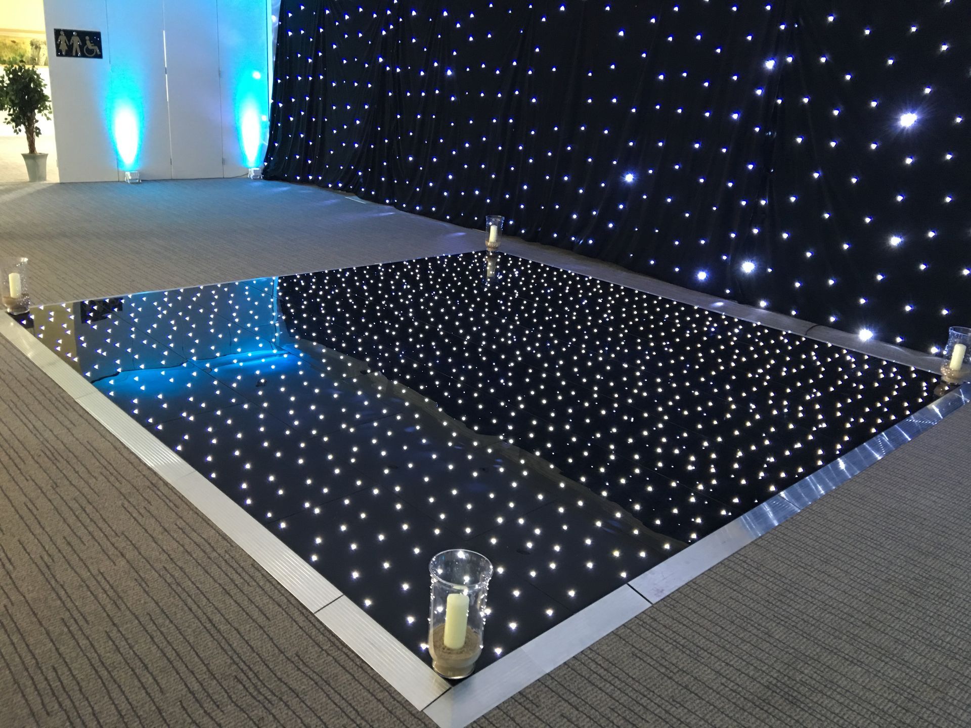 Large event space lit with cool white and blue lighting. Black base with sparkly white lights for this light up dance floor. Production services and equipment  hire for this event was supplied by Exclusive Entertainments Harrogate,Yorkshire