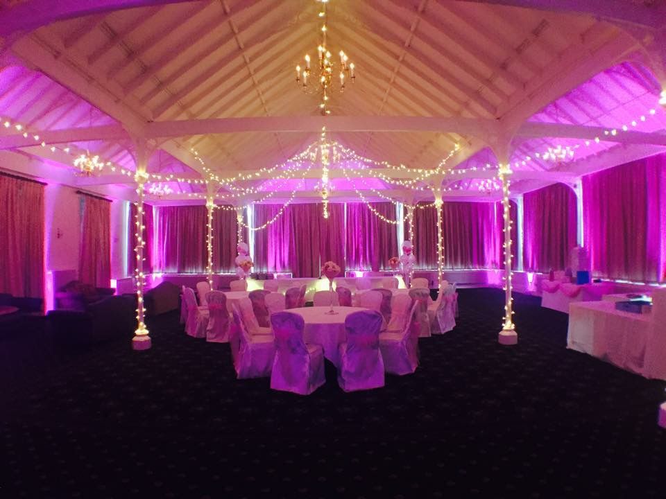 Warm white lights meet under a chandler with bright pink lights illuminating the edge of the event space Decor, Production services and equipment hire for this event was supplied by Exclusive Entertainments Harrogate,Yorkshire