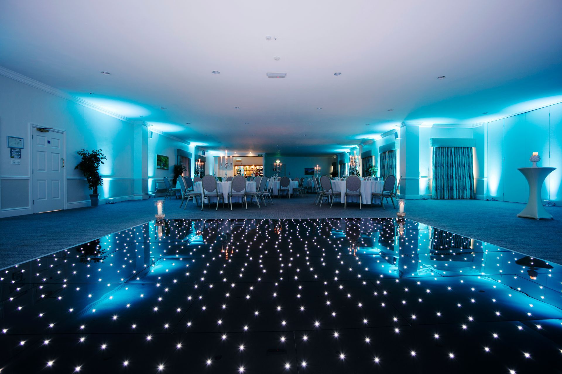 Large event space lit with cool white and blue lighting. Black base with sparkly white lights for this light up dance floor. Production services and equipment  hire for this event was supplied by Exclusive Entertainments Harrogate,Yorkshire