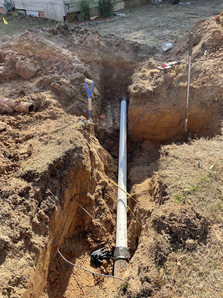 A pipe is being installed in a hole in the ground.