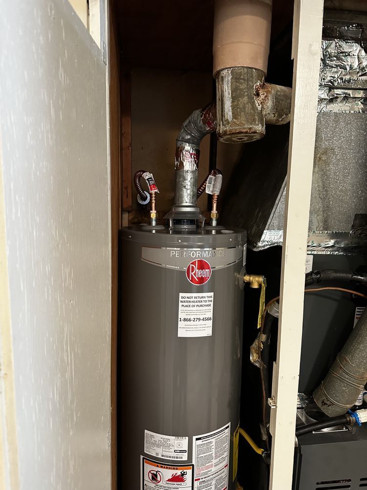 A Rheem water heater installed inside a closet with ductwork visible.