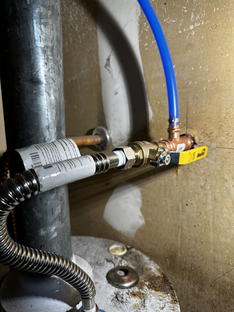 A close up of a water heater with a blue hose attached to it.