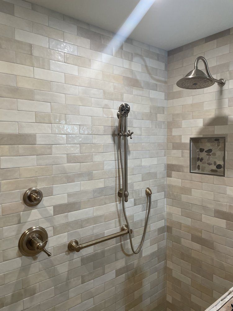 A shower with a hand rail and a shower head.