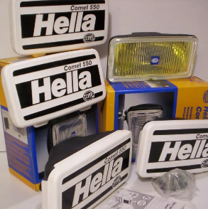 Surtido de faros y embalajes para automóviles Hella Comet 550, principalmente blancos y negros, con una lámpara amarilla.