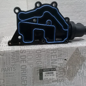 Pieza automotriz negra con contorno de junta azul sobre una caja de repuestos originales Renault y fondo de papel.