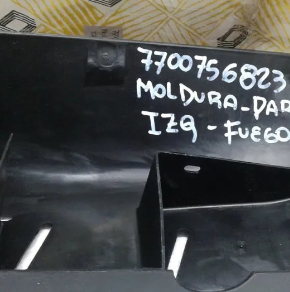 Pieza de metal negro con marcas y números escritos a mano en blanco sobre una superficie de trabajo.