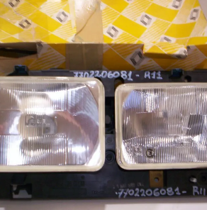 Dos faros rectangulares de coche con carcasas negras sobre un fondo amarillo estampado.