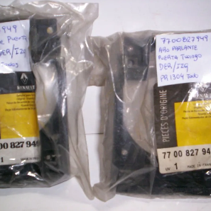 Dos piezas de automóvil negras empaquetadas en plástico transparente con etiquetas escritas a mano en la parte superior.