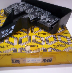 Pieza de plástico negro de un coche Renault, colocada sobre una caja amarilla de Renault.