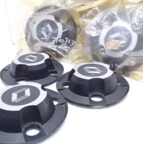 Componentes electrónicos circulares de color negro y plateado con orificios de montaje, dispuestos sobre una superficie clara.