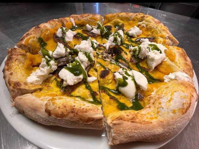 Una pizza è appoggiata su un bancone di marmo.
