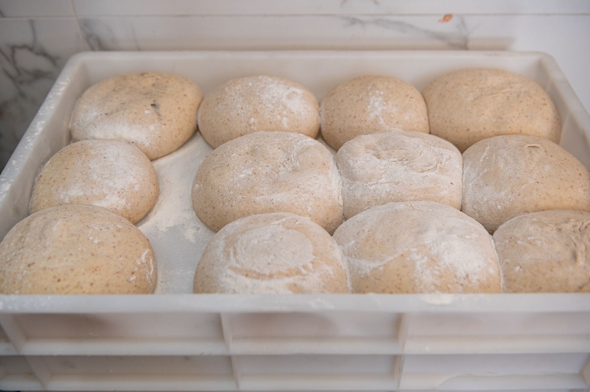 Un vassoio pieno di palline di pasta in una panetteria.