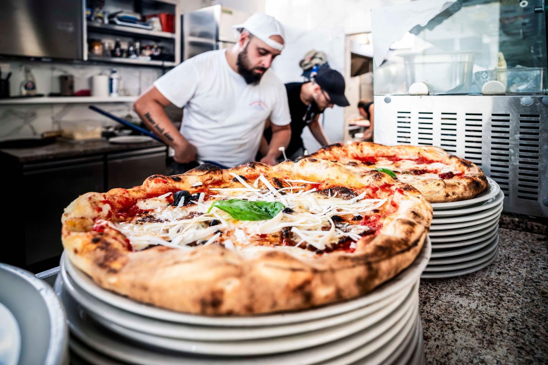 Un tavolo con quattro pizze e una bottiglia di champagne sopra