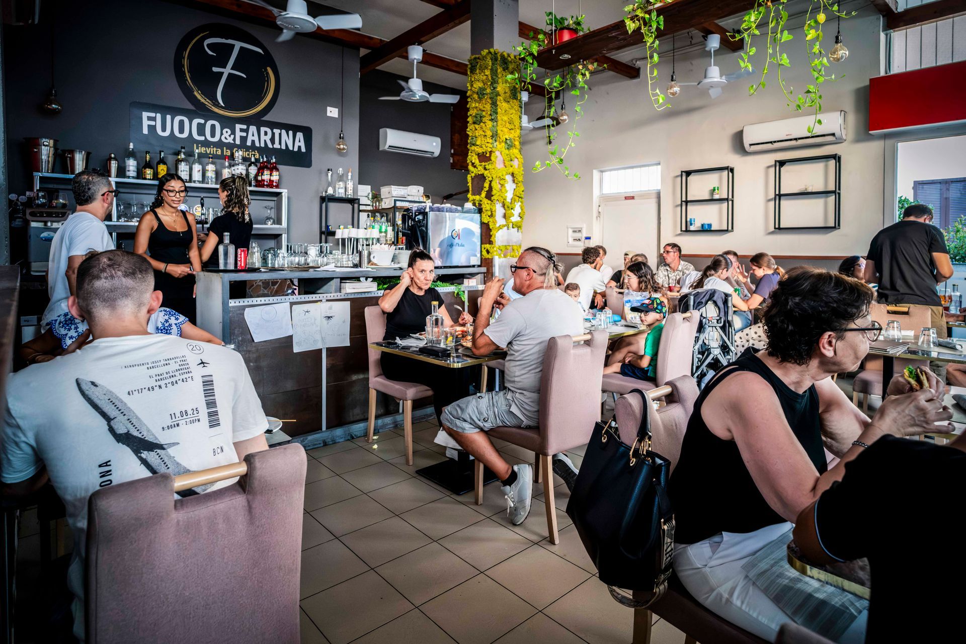 Un ristorante con tavoli e sedie e un dipinto di una donna sul muro.