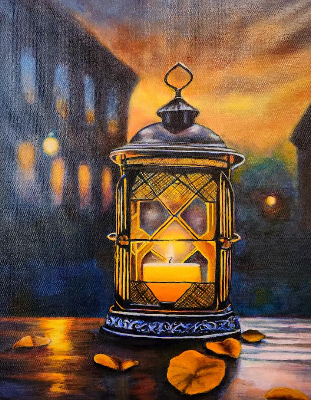 Lit lantern on a table with fall leaves in front of a blurred city scene at dusk; golden light.