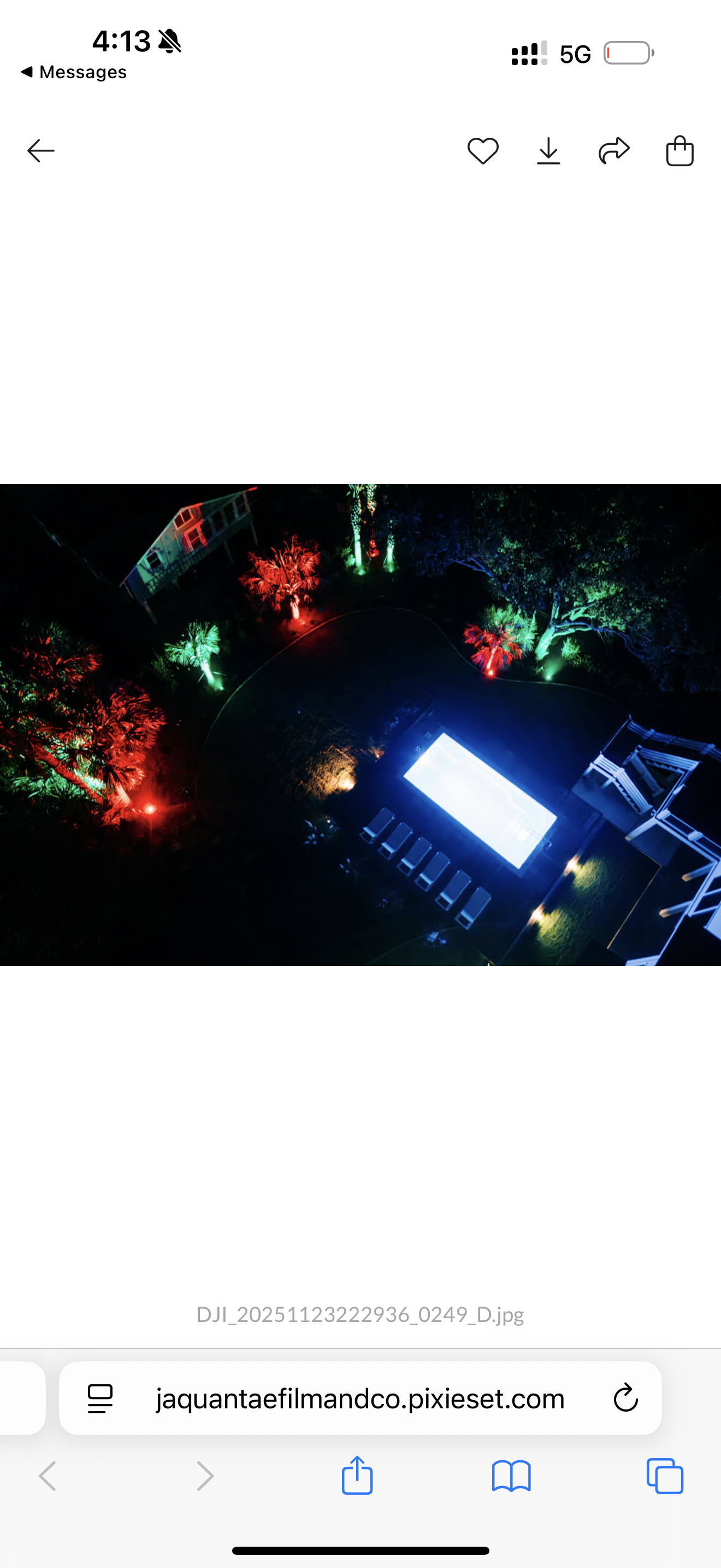 An aerial view of a dark area with colorful lights and a blue lit structure.