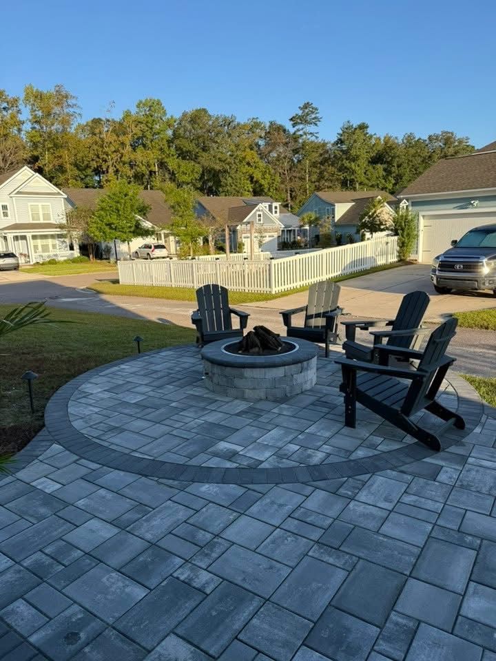 Outdoor patio with fire pit and Adirondack chairs, in a suburban setting.