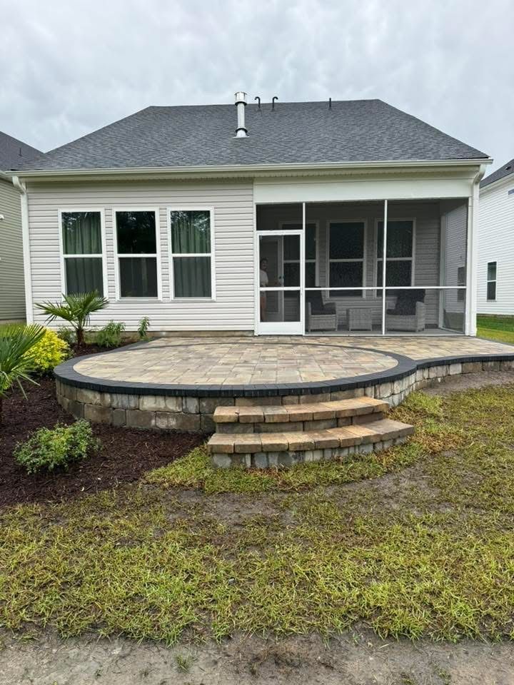 Backyard patio with a screened porch, brickwork, and steps.