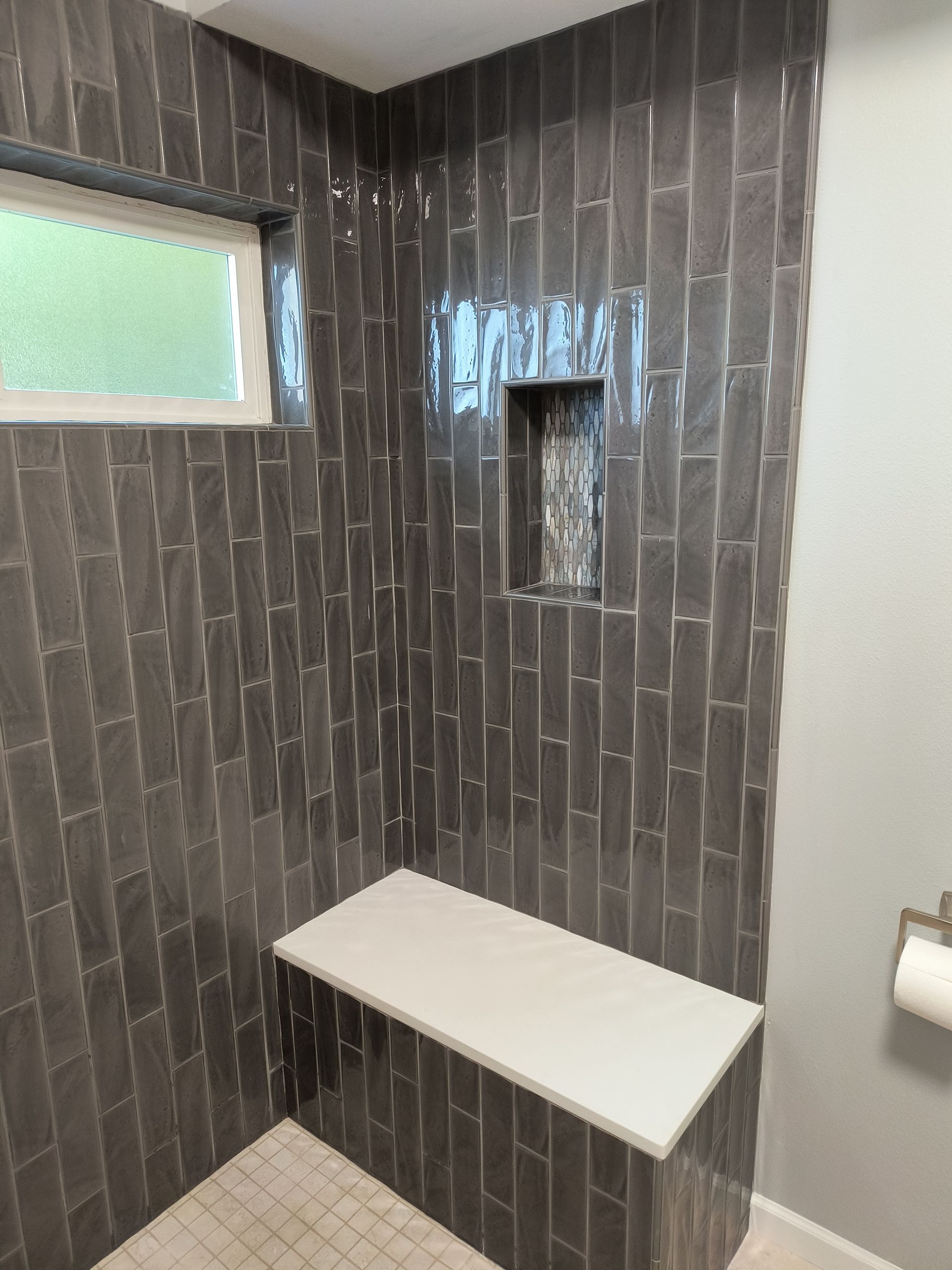 Walk-in tile shower with a built-in bench and recessed niche in a bathroom remodel in Bellingham, WA.