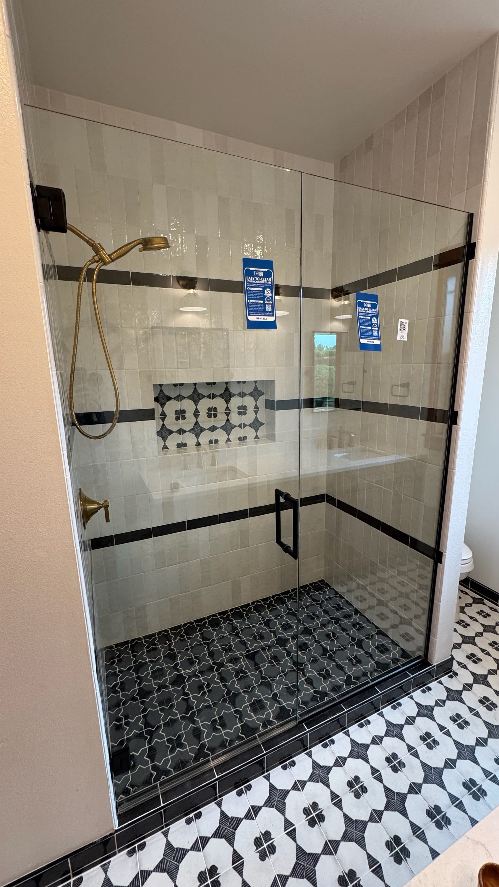 Walk-in shower with a frameless glass enclosure and decorative tile in a bathroom remodel in Bellingham, WA.