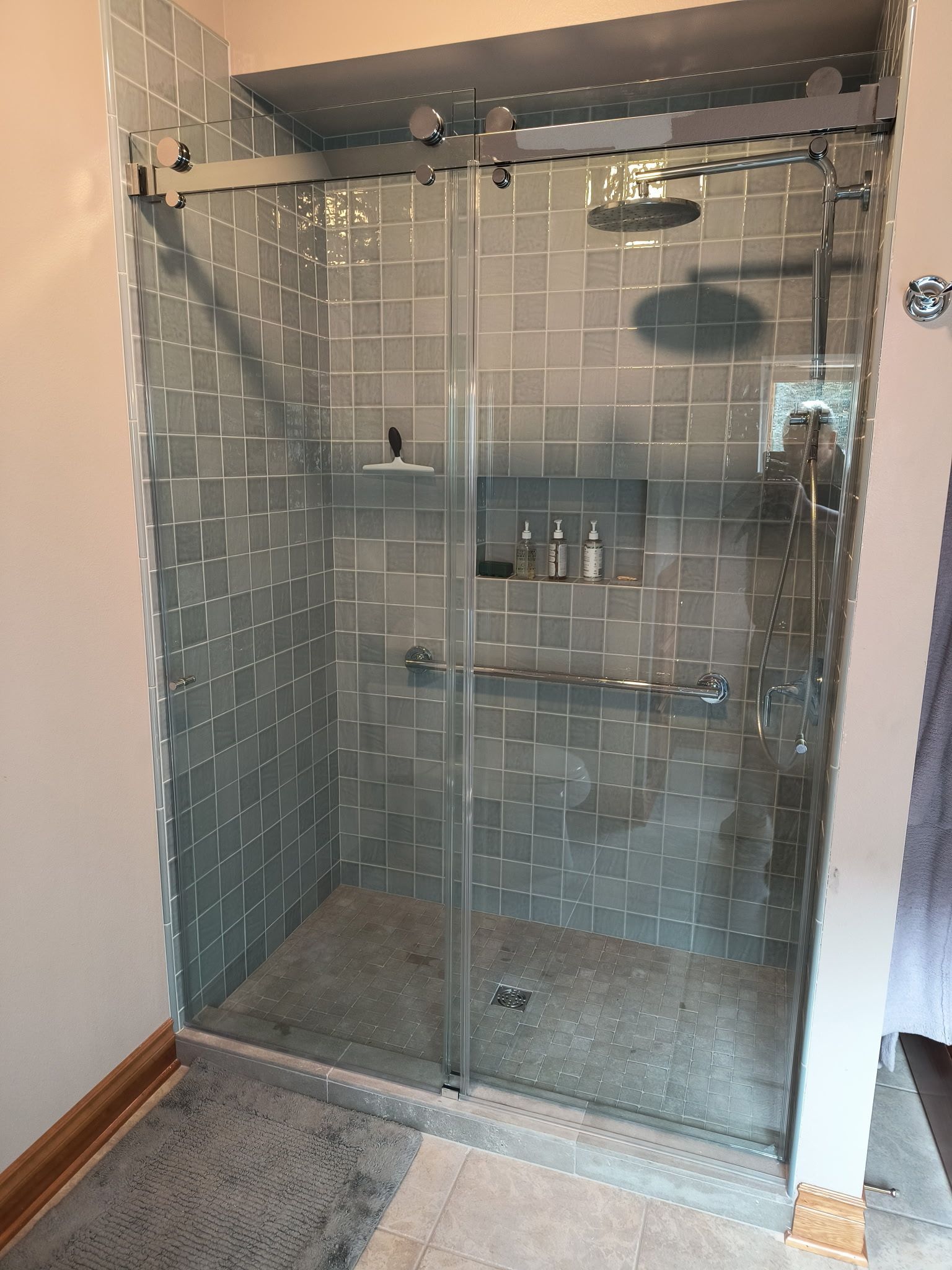 Walk-in tile shower with a frameless glass enclosure in a bathroom remodel in Bellingham, WA.