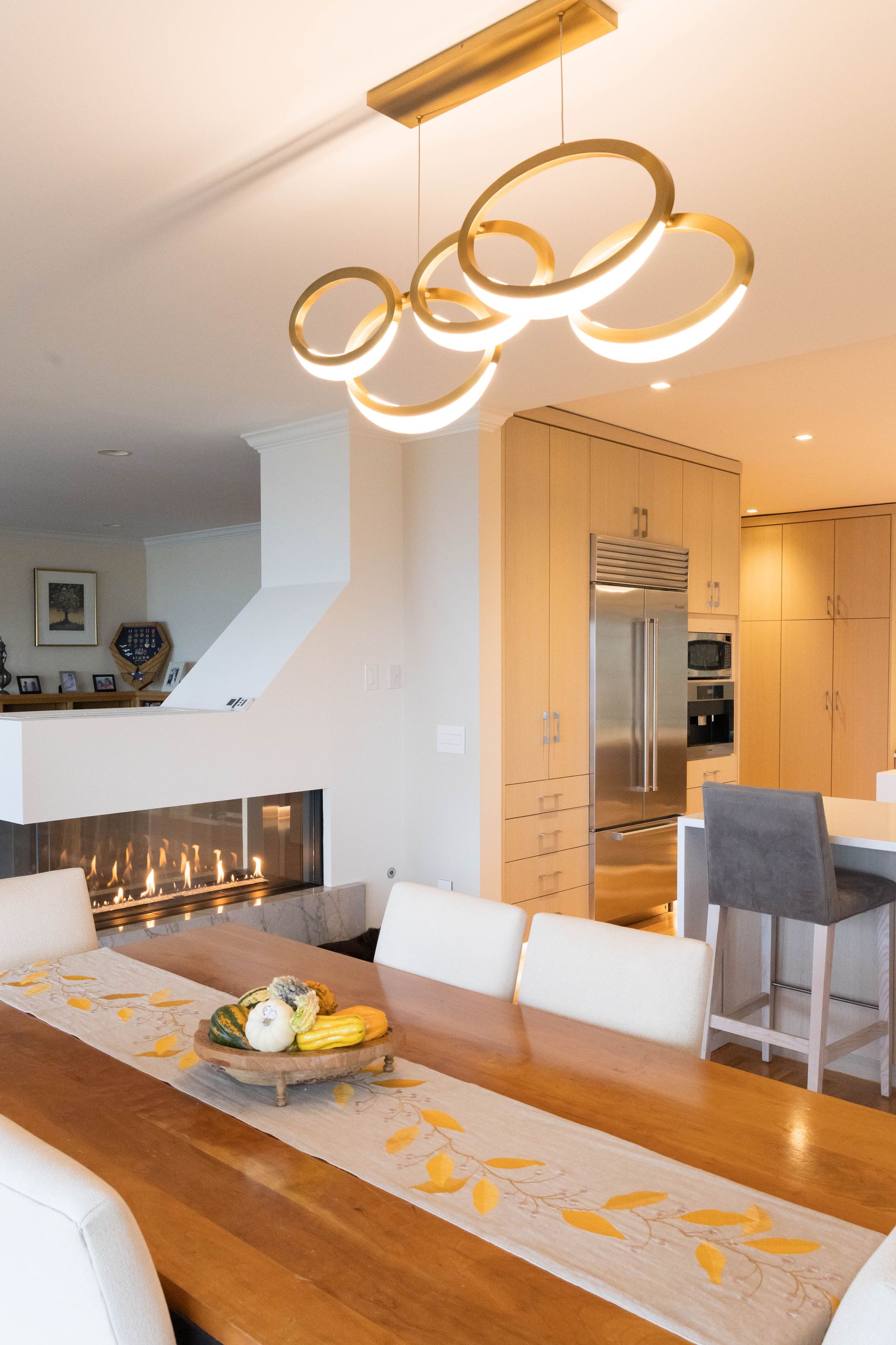 Remodeled kitchen and dining area in Lynden, WA with custom cabinetry, modern lighting, hardwood floors, and fireplace.