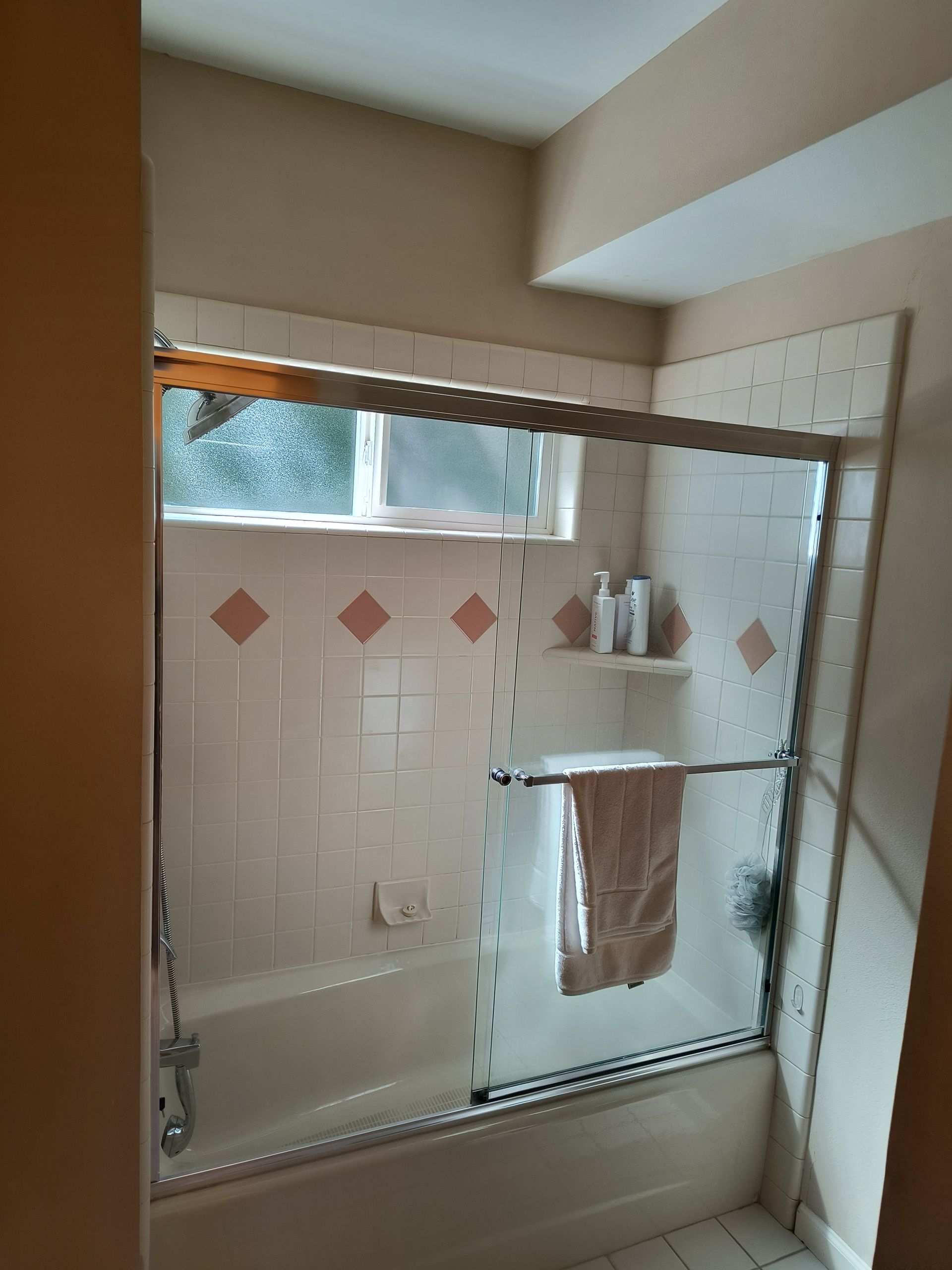 Before bathroom remodel with outdated tile shower in Bellingham, WA.