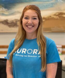 A smiling woman in a blue t-shirt with