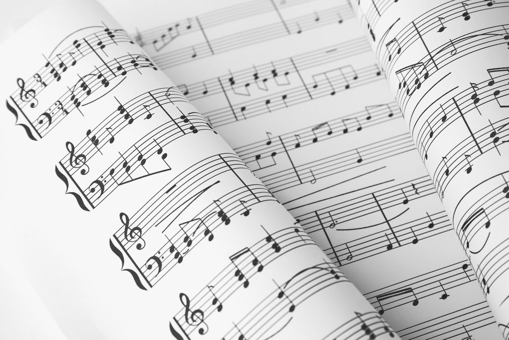A close up of a sheet of music with a treble clef