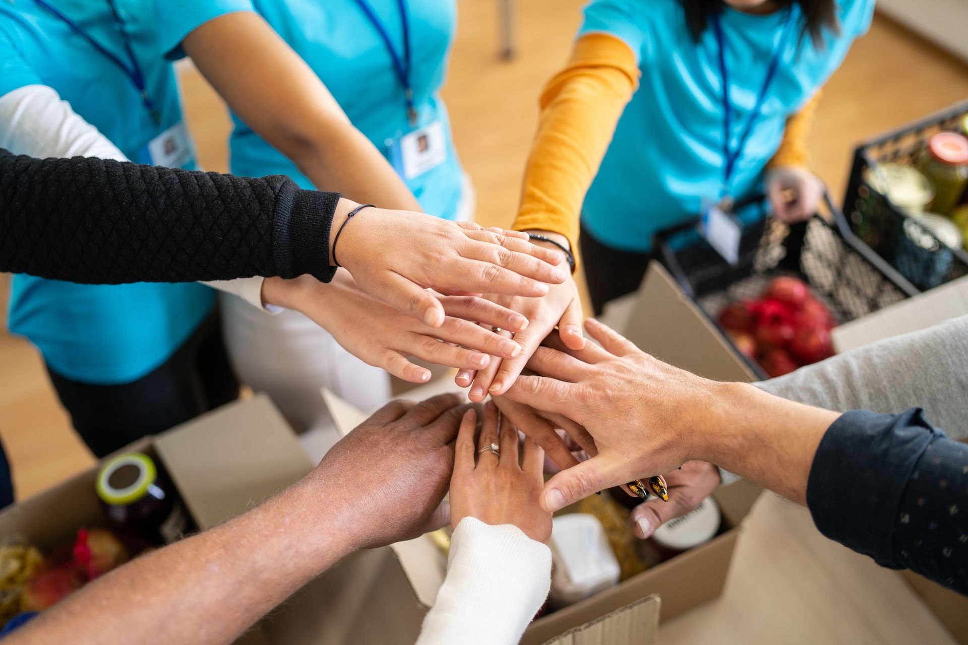 A group of people are putting their hands together in a huddle.