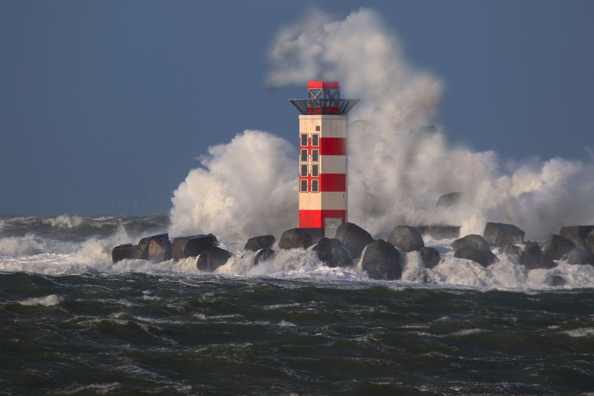 Lighthouse standing tall and strong in a storm and powerful waves