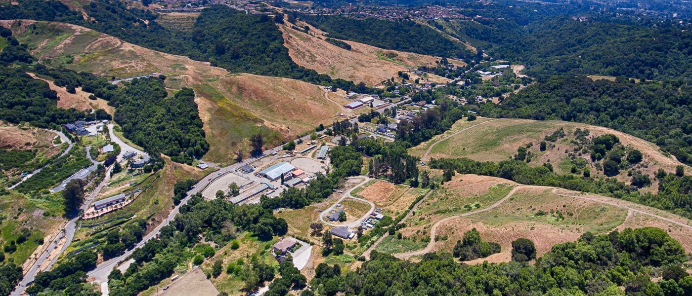 An aerial view of a valley filled with lots of trees and hills.