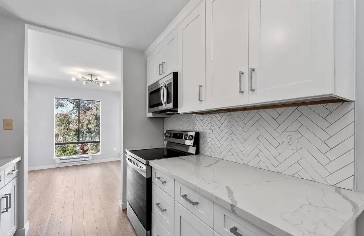 A kitchen with white cabinets and stainless steel appliances.