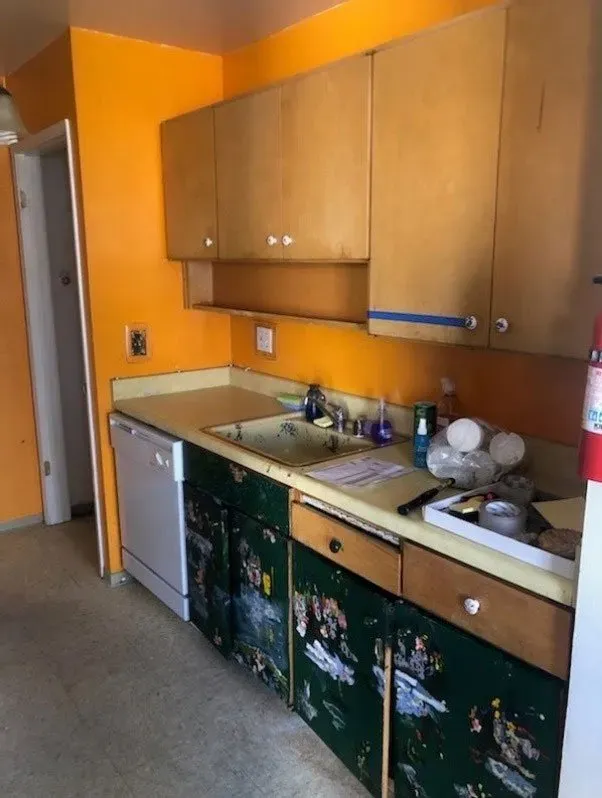 A kitchen with yellow walls and green cabinets