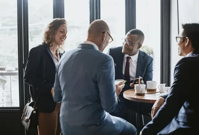 A group of business people are sitting at a table having a meeting.