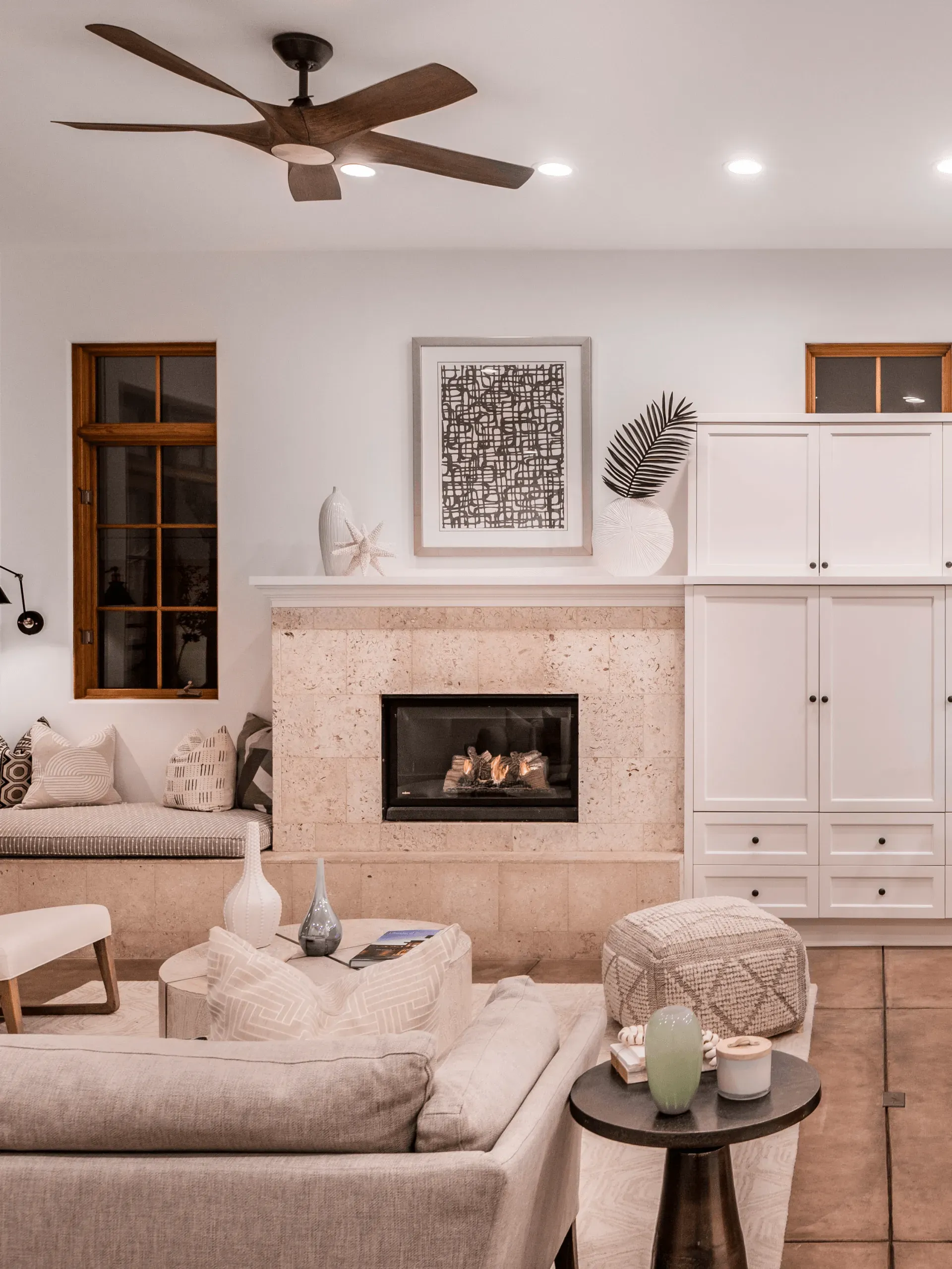 A living room with a fireplace and a ceiling fan