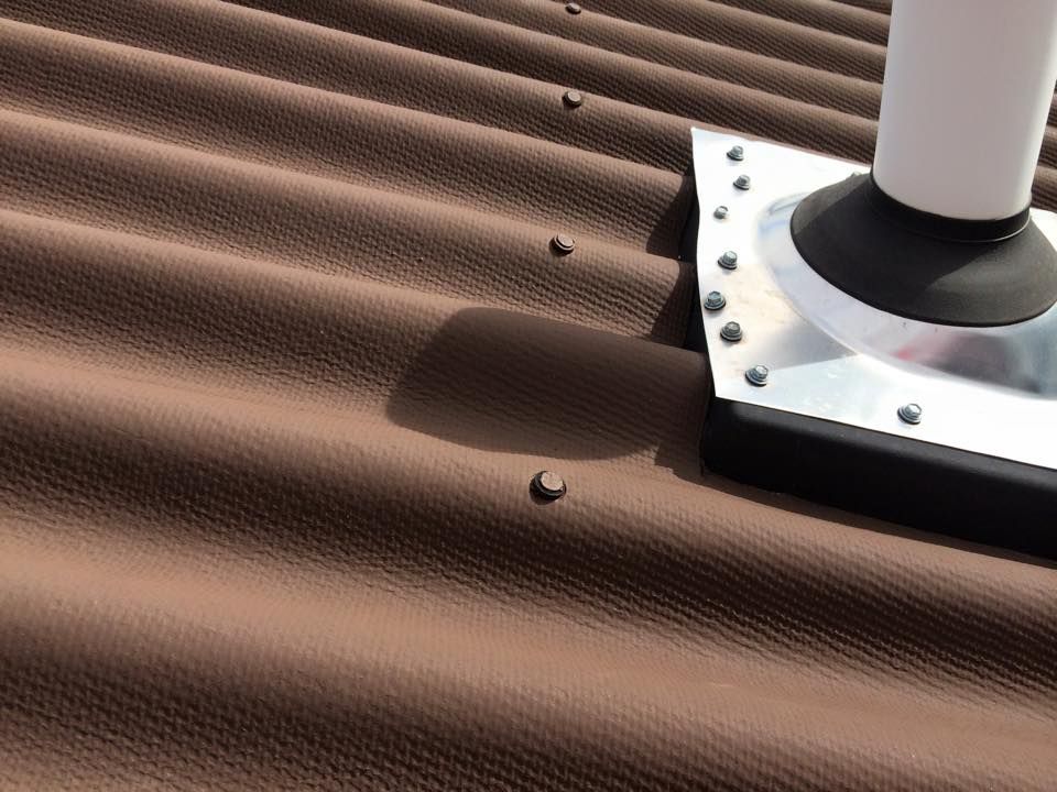 Solar panel roof with scattered hailstones and a roof vent in the corner