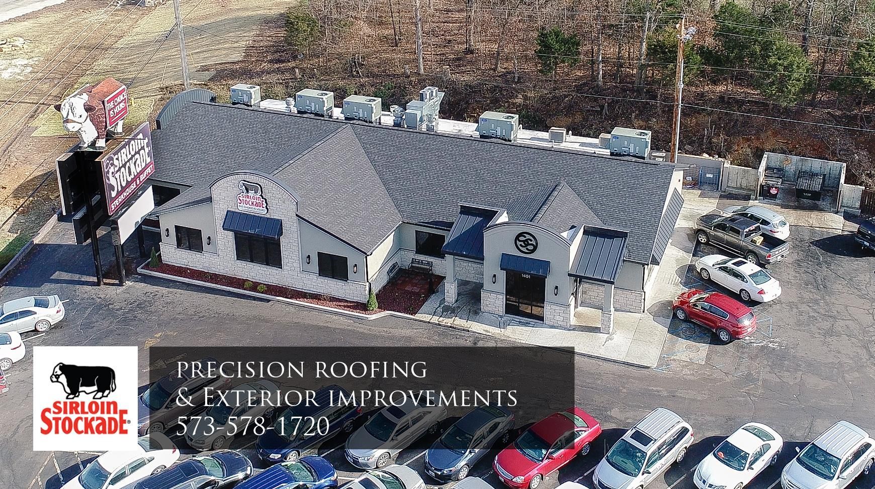 Aerial view of a single-story business building with a parking lot and sign for Pearson Roofing & Exterior Improvements.