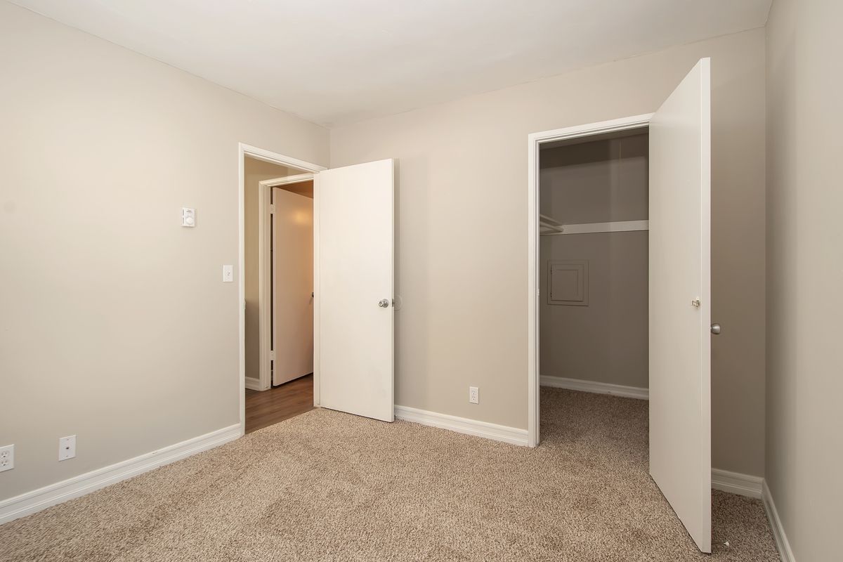 an empty bedroom with two doors open and a closet .