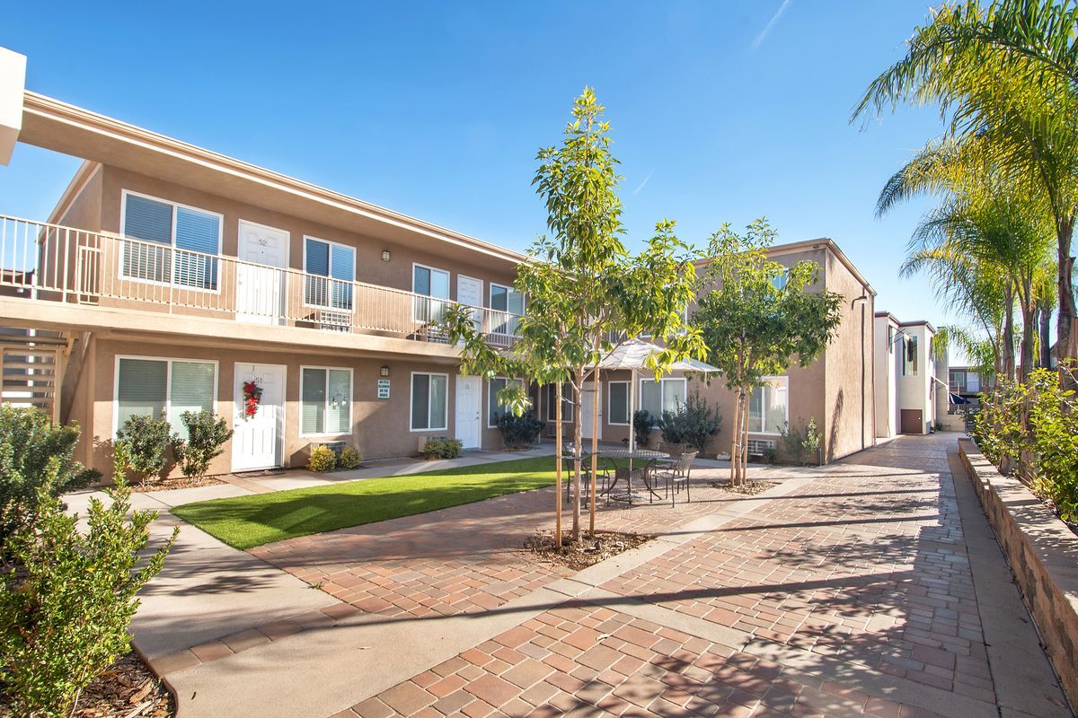 a large apartment building with a brick walkway leading to it .