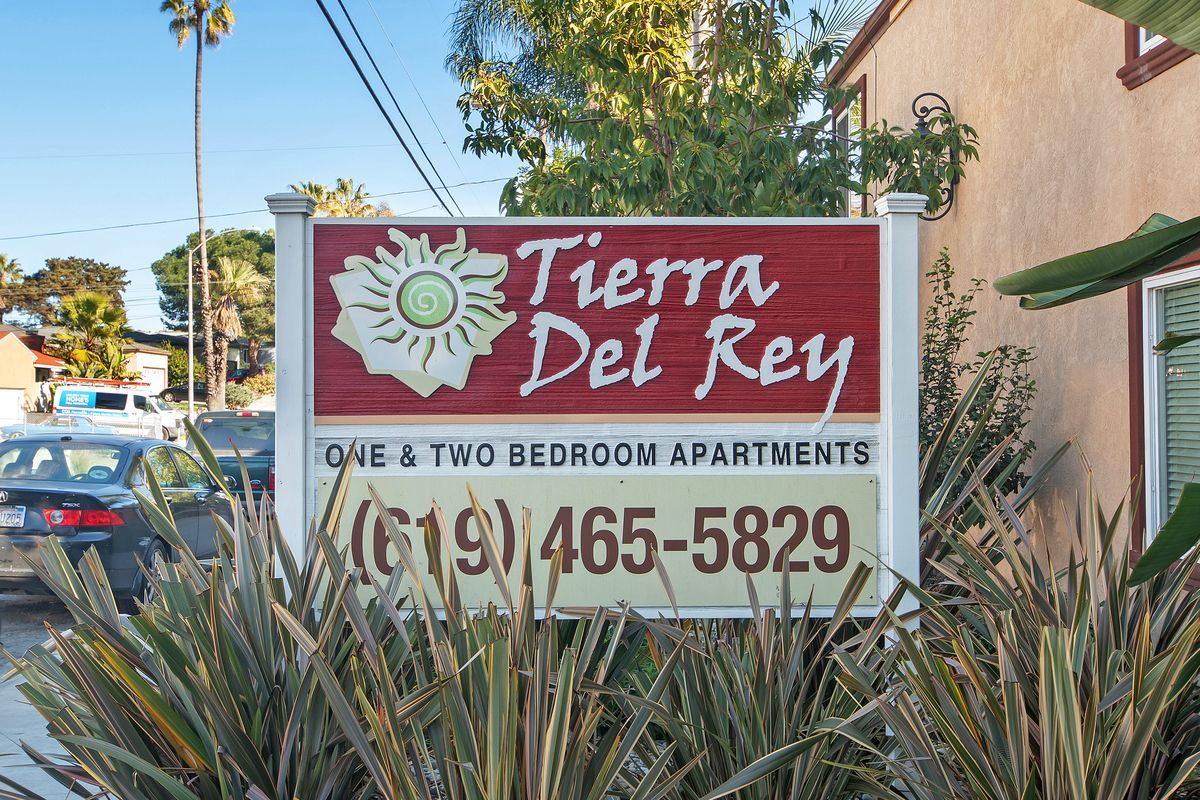 a sign for tierra del rey apartments is in front of a building
