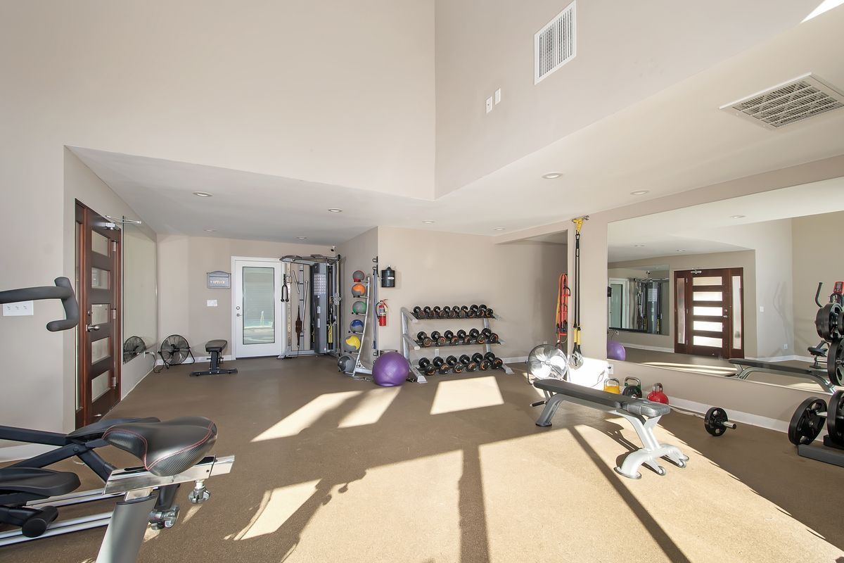a large gym with a lot of equipment and a large mirror