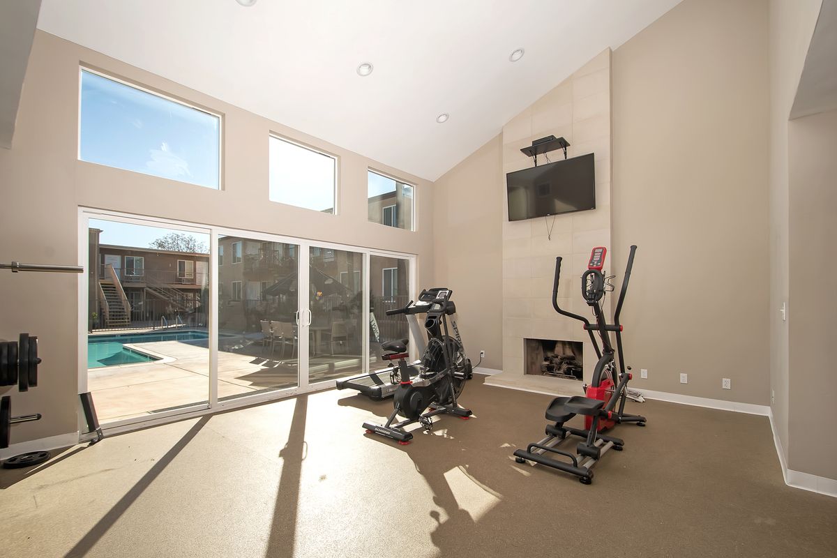 a gym with a sliding glass door leading to a pool