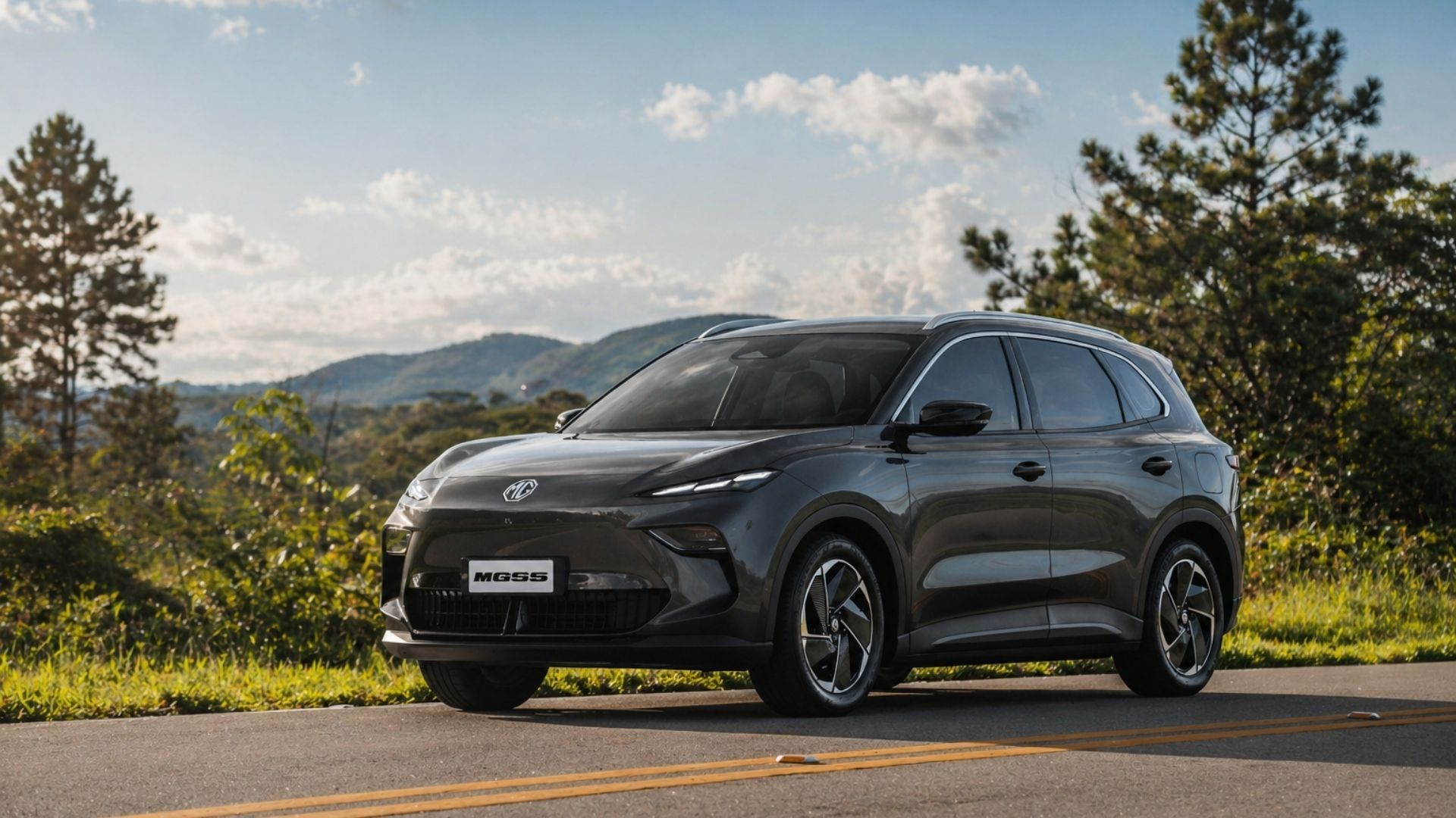 Dark gray SUV parked on a road with mountains and trees in the background under a partly cloudy sky